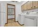 Laundry room with tile floors, white appliances and cabinetry, located near the hallway and other living spaces at 1221 Candlelight Blvd, Brooksville, FL 34601