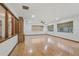Bright living room with hardwood floors, multiple windows, and a built-in shelving unit at 1221 Candlelight Blvd, Brooksville, FL 34601