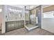 The bathroom features a glass shower, gray tile and cabinets, and two circular mirrors at 1410 Monte Lake Dr, Valrico, FL 33596