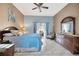 Bedroom with blue accents, ceiling fan, dresser with ornate mirror and outdoor access through sliding glass door at 1410 Monte Lake Dr, Valrico, FL 33596
