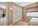 Bedroom featuring wood laminate floors, bi-fold closet door, and window at 1410 Monte Lake Dr, Valrico, FL 33596