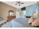 Bedroom with ceiling fan, TV and dresser with ornate mirror on blue accent wall at 1410 Monte Lake Dr, Valrico, FL 33596