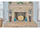 Brick fireplace with mantle has floral arrangement, vases and plate with a sunflower motif at 1410 Monte Lake Dr, Valrico, FL 33596