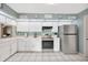 A kitchen featuring white cabinetry, stainless steel appliances and decorative wall decor at 1410 Monte Lake Dr, Valrico, FL 33596
