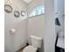 Powder room featuring arched window, toilet and decorative mirrors at 1410 Monte Lake Dr, Valrico, FL 33596