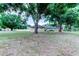 Expansive backyard with mature trees, a shed, and a full view of the house's rear exterior at 15302 Lake Maurine Dr, Odessa, FL 33556
