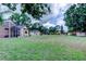 Large, well-maintained backyard featuring a house, detached garage, screened-in patio, and ample green space at 15302 Lake Maurine Dr, Odessa, FL 33556