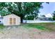 Backyard with a shed, a white fence, and a large tree, providing privacy and space at 15302 Lake Maurine Dr, Odessa, FL 33556