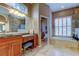 Elegant bathroom with dual vanities, garden tub, and walk-in shower featuring decorative tile accents at 15302 Lake Maurine Dr, Odessa, FL 33556