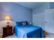 Comfortable bedroom with a plush blue bed, classic wooden nightstand, and ample closet space at 15302 Lake Maurine Dr, Odessa, FL 33556