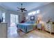 Light-filled primary bedroom boasts a neutral palette, travertine floors, and sliding glass doors to the lanai at 15302 Lake Maurine Dr, Odessa, FL 33556