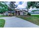 Charming single-story home featuring a well-manicured lawn, mature landscaping, and a concrete driveway at 15302 Lake Maurine Dr, Odessa, FL 33556