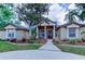 Charming single-story home featuring a well-manicured lawn, mature landscaping, and inviting column-supported front porch at 15302 Lake Maurine Dr, Odessa, FL 33556