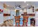 Well-lit kitchen with white cabinets, a granite island, and barstool seating at 15302 Lake Maurine Dr, Odessa, FL 33556