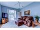 Comfortable living room with a leather couch, window seat, and access to outdoor pool area at 15302 Lake Maurine Dr, Odessa, FL 33556