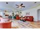 Open-concept living room featuring hardwood floors and comfortable leather seating with modern ceiling fan at 15302 Lake Maurine Dr, Odessa, FL 33556