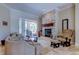 Bright and airy living room featuring a stone fireplace, plush seating, and sliding glass doors at 15302 Lake Maurine Dr, Odessa, FL 33556