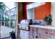 Outdoor kitchen has stainless steel grill with brick surround, sink and ample counter space at 15302 Lake Maurine Dr, Odessa, FL 33556