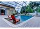Relaxing screened pool with in-water seating and waterfall feature for backyard enjoyment at 15302 Lake Maurine Dr, Odessa, FL 33556
