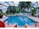 Inviting screened-in pool area with lounge chairs and lush, tropical landscaping at 15302 Lake Maurine Dr, Odessa, FL 33556