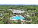 Aerial view of the community clubhouse with a pool, splash pad, waterslide, playground, pond, and ample green space at 16343 Burniston Dr, Tampa, FL 33647