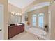 Bright bathroom features a soaking tub and dual windows at 16343 Burniston Dr, Tampa, FL 33647