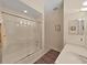 Bathroom with tub and shower combination with glass doors, complemented by a stylish vanity at 16343 Burniston Dr, Tampa, FL 33647