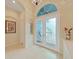 Elegant foyer with tile flooring, decorative front doors, and arched transom window at 16343 Burniston Dr, Tampa, FL 33647