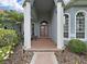 Elegant front entrance with stately columns and double doors, complemented by lush landscaping at 16343 Burniston Dr, Tampa, FL 33647