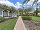 Landscaped walkway leading to a beautiful home with lush green lawns and well-maintained shrubs at 16343 Burniston Dr, Tampa, FL 33647