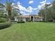 A captivating single-story home with a lush green lawn, mature landscaping, and a classic tile roof at 16343 Burniston Dr, Tampa, FL 33647