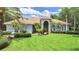 Stunning single-story home featuring a beautiful lawn, manicured landscaping, and a classic tile roof at 16343 Burniston Dr, Tampa, FL 33647