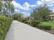 Long driveway leading to a well-manicured home with verdant landscaping, shrubs, and palm trees at 16343 Burniston Dr, Tampa, FL 33647