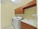Functional laundry area featuring washer and dryer, complemented by a built-in utility sink and cabinets at 16343 Burniston Dr, Tampa, FL 33647