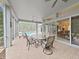 Covered patio featuring ceiling fans, tile flooring, and a dining set; it connects to the interior through sliding glass doors at 16343 Burniston Dr, Tampa, FL 33647