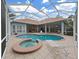 Resort-style screened-in pool area with sparkling pool, hot tub, and ample patio space at 16343 Burniston Dr, Tampa, FL 33647