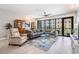 Spacious living room boasting large windows, wood-look tile, comfortable seating, and stylish decor at 199 Dali Blvd # 403, St Petersburg, FL 33701