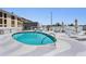 Community pool with lounge chairs, umbrellas, and a hot tub at 199 Dali Blvd # 403, St Petersburg, FL 33701