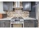 Close-up of stainless steel range with mosaic backsplash and modern cabinetry at 199 Dali Blvd # 403, St Petersburg, FL 33701