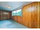 Cozy bedroom featuring wood paneling, carpet, and a bright window at 2003 Waikiki Way, Tampa, FL 33619