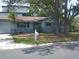 Charming one-story home with a well-maintained front yard, mature trees, and a paved driveway leading to the garage at 212 Driftwood Pl, Palm Harbor, FL 34683
