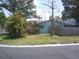 View of charming home with mature trees, lush landscaping, and a privacy fence at 212 Driftwood Pl, Palm Harbor, FL 34683