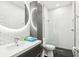 Sleek bathroom features a glass-enclosed shower, a modern vanity with a round mirror, and designer tile at 2222 Longmore Cir, Valrico, FL 33596