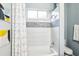 Bathroom with modern shower and tub features white and gray tile, geometric shower curtain, and plenty of light at 2222 Longmore Cir, Valrico, FL 33596