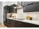 Updated kitchen with stainless steel appliances, modern backsplash, and dark cabinetry at 2222 Longmore Cir, Valrico, FL 33596