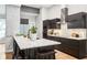 Modern kitchen featuring sleek dark cabinetry, stainless steel appliances, and a stylish waterfall island with seating at 2222 Longmore Cir, Valrico, FL 33596
