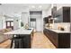 Contemporary kitchen with black cabinetry, a large island, and hardwood floors is adjacent to the living area at 2222 Longmore Cir, Valrico, FL 33596