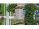Aerial view of home with screened pool, lush landscaping, and a gray roof at 2413 Buckhorn Run Dr, Valrico, FL 33596