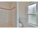 Bathroom displaying tiled walls, a bathtub, and a window providing natural light at 2413 Buckhorn Run Dr, Valrico, FL 33596