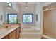 Bathroom with a luxurious soaking tub under a stained glass window and a glass-enclosed shower at 2413 Buckhorn Run Dr, Valrico, FL 33596